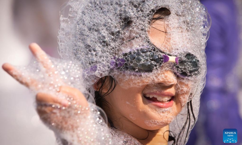 A girl poses for photos while having fun in the foam during the 2024 Chinese Cultural Heritage Festival and Vancouver Water Splashing Festival in Burnaby, British Columbia, Canada, July 27, 2024. The two-day events kicked off here on Saturday. Photo: Xinhua