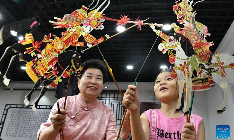 A pupil learns to play shadow puppet at a primary school in Hejian, north China's Hebei Province, July 26, 2024. Various training courses on intangible cultural heritages as shadow puppet, porcelain carving etc. targeting the school children are opened in the city during the summer vacation. Photo: Xinhua