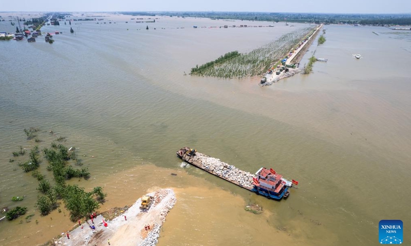 An aerial drone photo shows rescuers working to block the dike breach in the Dongting Lake in Huarong County, central China's Hunan Province, July 7, 2024. (Xinhua/Chen Sihan)