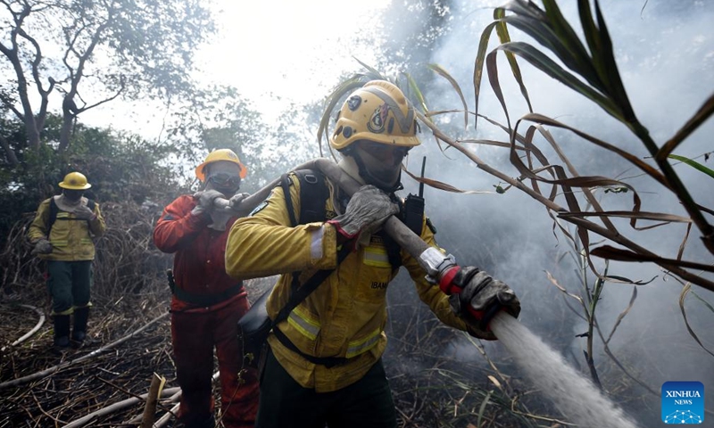 Firefighters work to put out a fire along Paraguay River in Pantanal, in Corumba, Mato Grosso do Sul, Brazil, July 7, 2024. (Photo by Lucio Tavora/Xinhua)