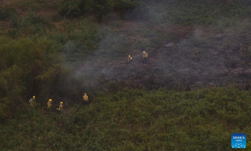 This aerial photo taken on July 7, 2024 shows firefighters trying to put out a fire along Paraguay River in Pantanal, in Corumba, Mato Grosso do Sul, Brazil, July 7, 2024. (Photo by Lucio Tavora/Xinhua)