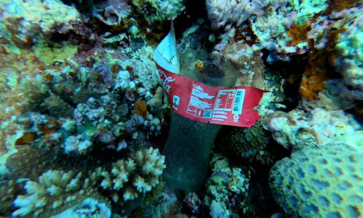 Photo taken by scientists who dived in the water near Ren'ai Jiao shows a piece of anthropogenic disposal (a barcode starting with 