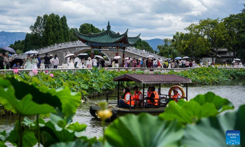 Visitors on boats enjoy lotus flowers at Daguan Park in Kunming, southwest China's Yunnan Province, July 7, 2024. (Xinhua/Hu Chao)