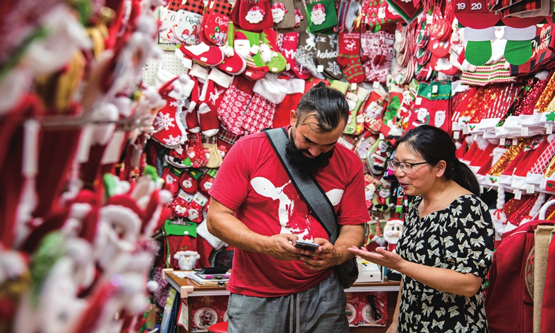 A consumer from Poland talks with a shop owner about purchasing Christmas products in Yiwu, East China's Zhejiang Province on July 9, 2024. Yiwu is the world's major supplier for global Christmas products. As summer is the peak season for shipments, a wide range of products will be shipped out after foreign merchants place their orders. Photo: VCG
