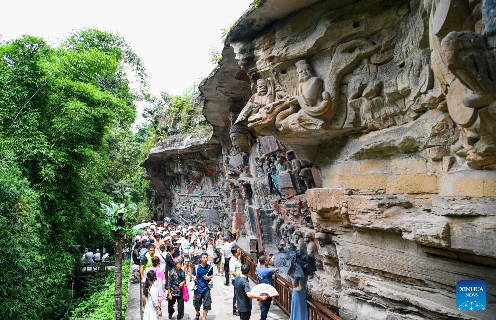 Tourists visit the scenic spot of Dazu Rock Carvings in southwest China's Chongqing, July 7, 2024. The Dazu Rock Carvings site was inscribed onto the UNESCO World Heritage List in 1999. The finest example of Chinese grotto art, the Dazu Rock Carvings site is of profound historical significance, embodying the vigorous vitality of Chinese culture. (Photo: Xinhua)