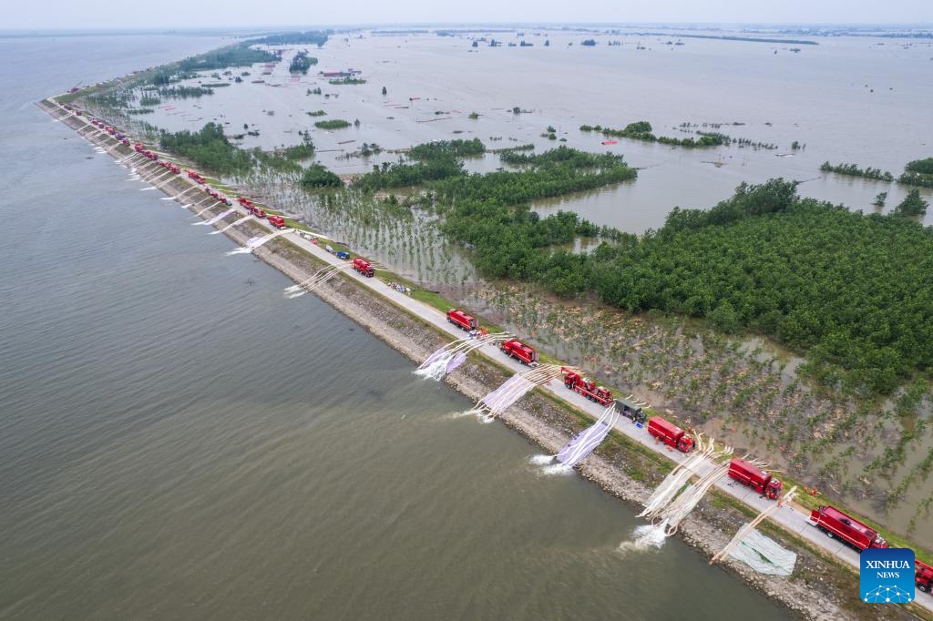 An aerial drone photo shows rescuers draining floodwater at a Dongting Lake dike in Tuanzhou Township, Huarong County under Yueyang City, central China's Hunan Province, July 9, 2024. The breach in the dike was successfully sealed late on Monday and work to drain flooded land and reduce risks are ongoing, according to authorities. (Photo: Xinhua)