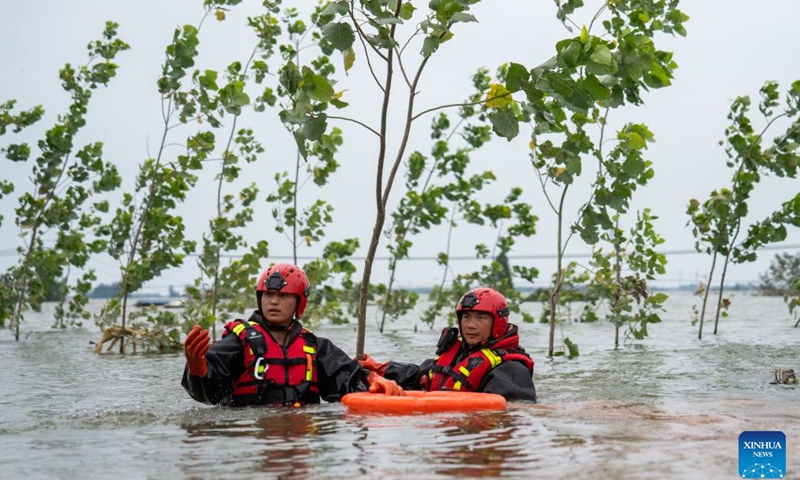 Rescuers drain floodwater at a Dongting Lake dike in Tuanzhou Township, Huarong County under Yueyang City, central China's Hunan Province, July 9, 2024. The breach in the dike was successfully sealed late on Monday and work to drain flooded land and reduce risks are ongoing, according to authorities. (Photo: Xinhua)