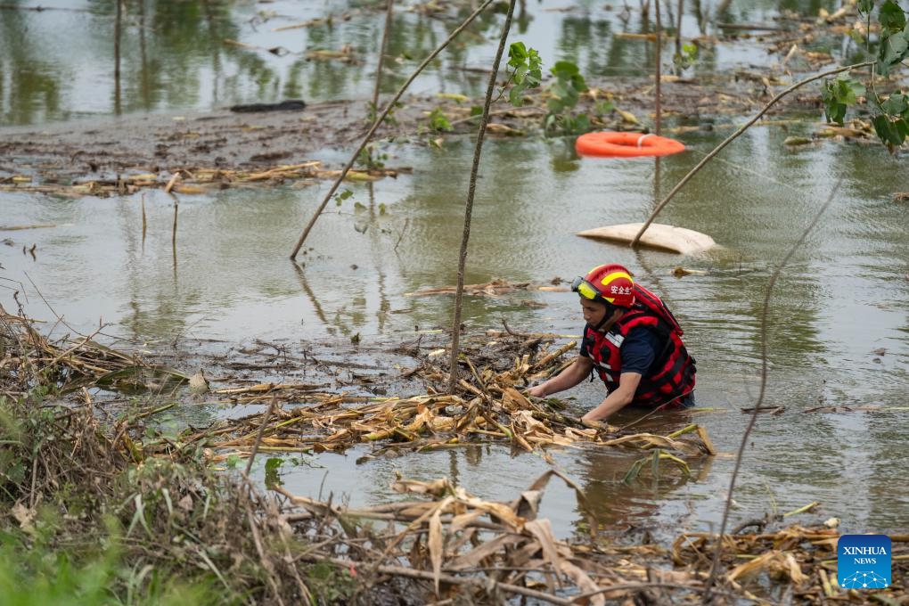 A rescuer prepares to drain floodwater at a Dongting Lake dike in Tuanzhou Township, Huarong County under Yueyang City, central China's Hunan Province, July 9, 2024. The breach in the dike was successfully sealed late on Monday and work to drain flooded land and reduce risks are ongoing, according to authorities. (Photo: Xinhua)