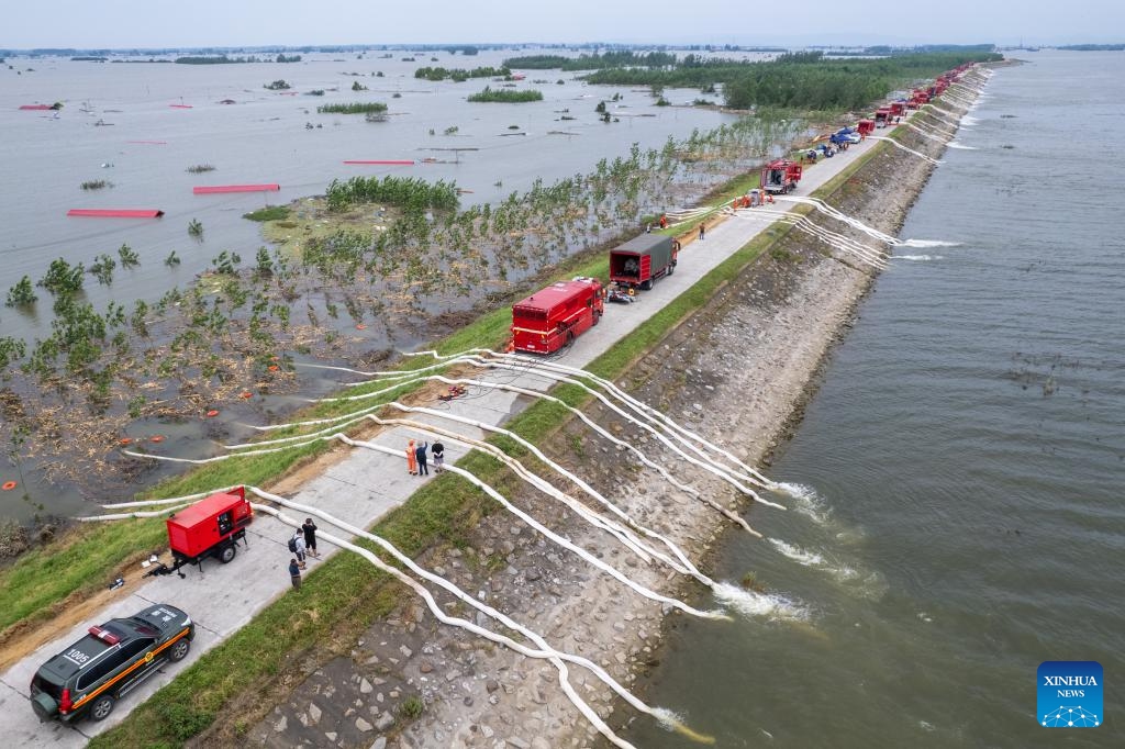 An aerial drone photo shows rescuers draining floodwater at a Dongting Lake dike in Tuanzhou Township, Huarong County under Yueyang City, central China's Hunan Province, July 9, 2024. The breach in the dike was successfully sealed late on Monday and work to drain flooded land and reduce risks are ongoing, according to authorities. (Photo: Xinhua)