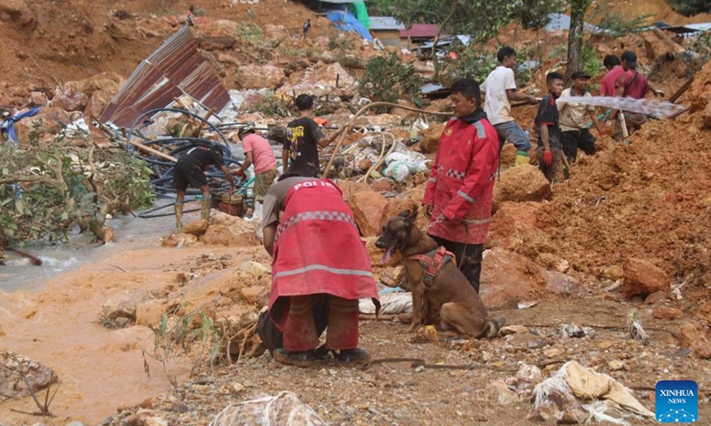 Police and a sniffer dog conduct rescue operation after landslides hit Tulabolo village in Bone Bolango regency, Gorontalo province, Indonesia, July 10, 2024. Indonesia on Tuesday nearly doubled the number of rescuers and deployed heavy machinery and a helicopter to search for victims of landslides and flash floods in Bone Bolango regency of Gorontalo province, according to a senior rescuer. (Photo: Xinhua)