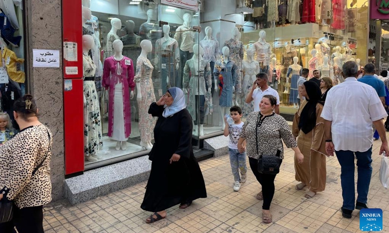 People walk past a clothing store in Cairo, Egypt, on July 10, 2024. Egypt's annual headline inflation rate dropped to 27.1 percent in June, down from 27.4 percent in May, continuing a downward trend for the fourth consecutive month, the country's statistics body reported on Wednesday. (Photo: Xinhua)