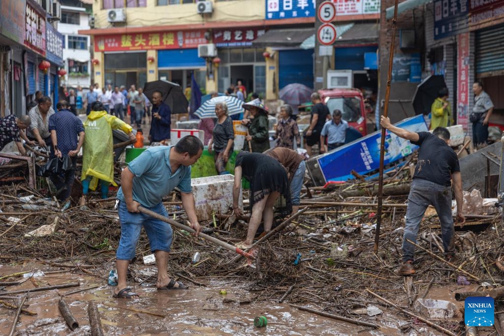 Local people clean up silt in Sanhui Town of Zhongxian County, southwest China's Chongqing, July 11, 2024. Torrential rains have recently hit Zhongxian County in Chongqing. After the flood receded, efforts were made to clean up the road, fix infrastructures and investigate hidden dangers in the hard-hit Sanhui Town. (Photo: Xinhua)