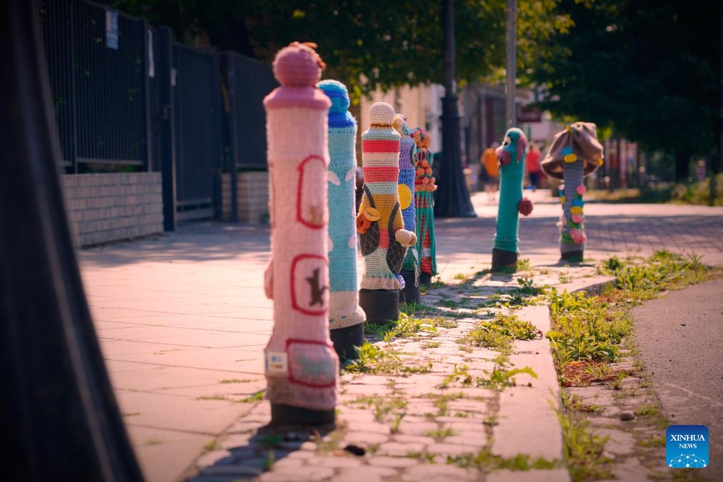 This photo taken on July 11, 2024 shows bollards adorned with woven fabrics by artisans in Praga district in Warsaw, capital of Poland. The Praga district is renowned for its vibrant cultural and creative atmosphere, with numerous galleries, museums, and designer studios. (Photo: Xinhua)