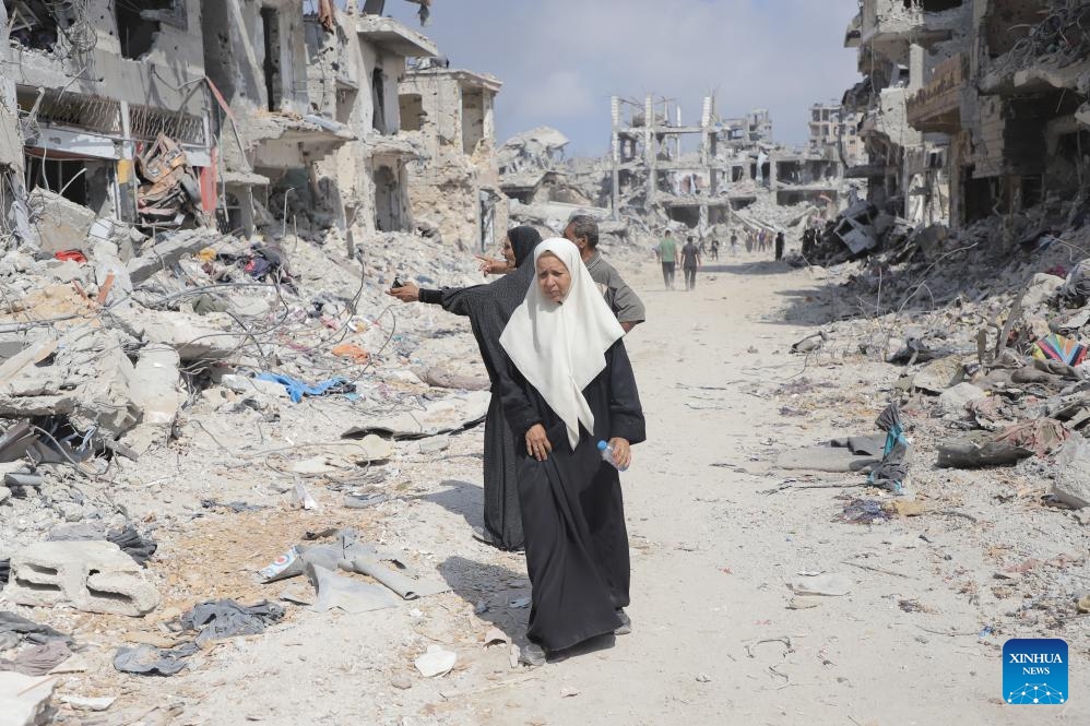 People are seen on a street with destroyed buildings in the Shujaiya neighborhood in east of Gaza City, on July 11, 2024. More than 60 bodies were recovered from the rubble in the eastern Gaza City neighborhood of Shujaiya after a prolonged Israeli ground offensive, the Palestinian official news agency WAFA reported on Thursday. (Photo: Xinhua)