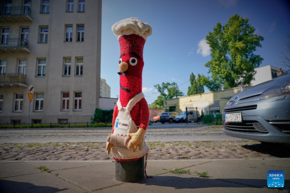 This photo taken on July 11, 2024 shows a bollard adorned with woven fabric by artisan in Praga district in Warsaw, capital of Poland. The Praga district is renowned for its vibrant cultural and creative atmosphere, with numerous galleries, museums, and designer studios. (Photo: Xinhua)