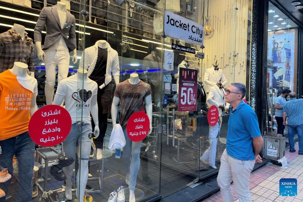 A man looks at a clothing store in Cairo, Egypt, on July 10, 2024. Egypt's annual headline inflation rate dropped to 27.1 percent in June, down from 27.4 percent in May, continuing a downward trend for the fourth consecutive month, the country's statistics body reported on Wednesday. (Photo: Xinhua)