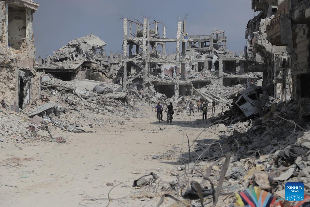 People are seen on a street with destroyed buildings in the Shujaiya neighborhood in east of Gaza City, on July 11, 2024. More than 60 bodies were recovered from the rubble in the eastern Gaza City neighborhood of Shujaiya after a prolonged Israeli ground offensive, the Palestinian official news agency WAFA reported on Thursday. (Photo: Xinhua)