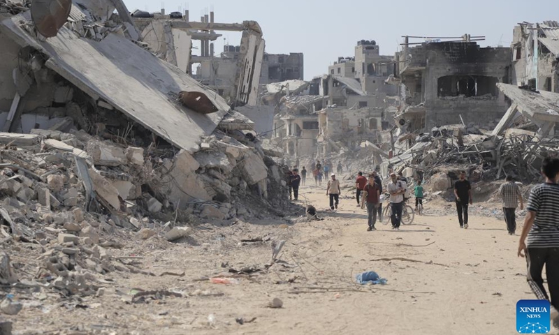 People are seen on a street with destroyed buildings in the Shujaiya neighborhood in east of Gaza City, on July 11, 2024. More than 60 bodies were recovered from the rubble in the eastern Gaza City neighborhood of Shujaiya after a prolonged Israeli ground offensive, the Palestinian official news agency WAFA reported on Thursday. (Photo: Xinhua)