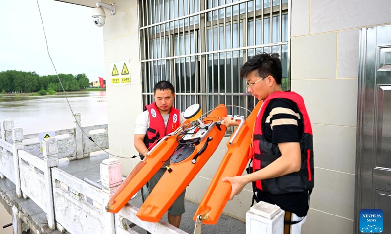 Staff members monitor the flood water at a hydrological station in Funan County of Fuyang, east China's Anhui Province, July 14, 2024. Measures including monitoring the flood water, inspecting embankment and ensuring flood-control materials have been taken by the authorities of Funan County of Fuyang, east China's Anhui Province, to control the No. 1 Flood for Huaihe River. (Xinhua/Huang Bohan)