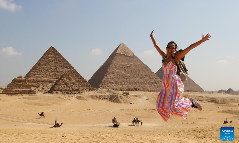 A tourist poses for photo at the Giza Pyramids scenic spot in Giza, Egypt, on July 14, 2024. Tourism revenue of Egypt hit 6.6 billion U.S. dollars in the first half of 2024, surpassing the 6.3 billion dollars during the same period in 2023. (Xinhua/Wang Dongzhen)