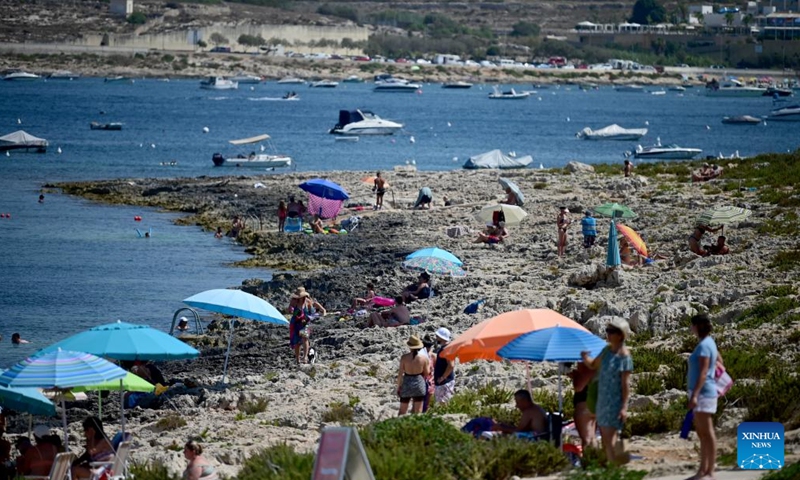 People cool off on a beach of St. Paul's Bay in Qawra, Malta, on July 14, 2024. (Photo by Jonathan Borg/Xinhua)