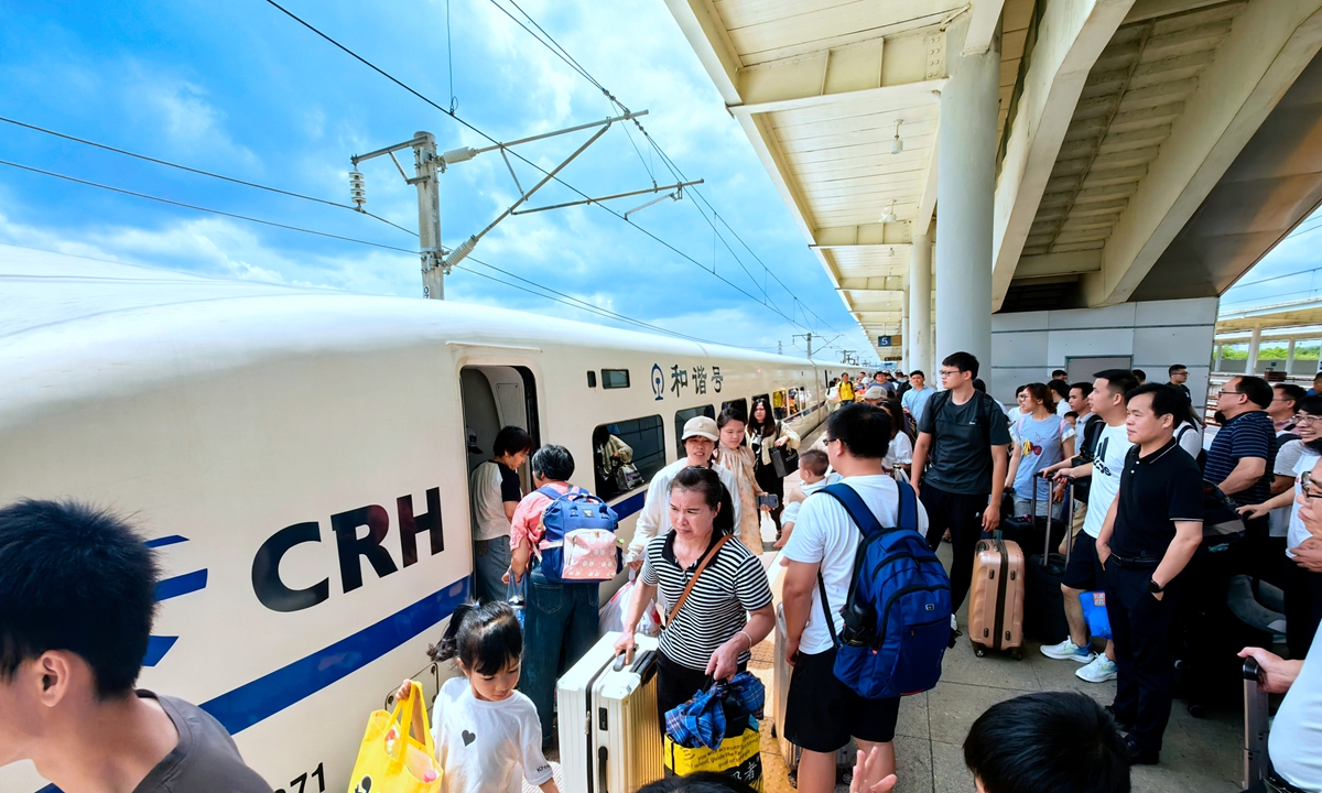 Passengers carry luggage to board a bullet train in Laibin North Station in South China's Guangxi Zhuang Autonomous Region on July 14, 2024 amid the summer travel rush which lasts until August 31. About 860 million railway trips are expected during this period. Photo: VCG