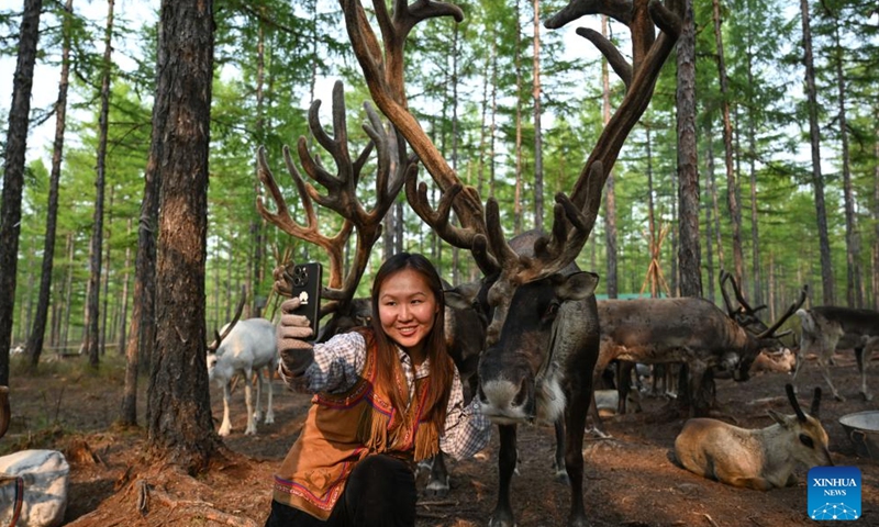 Ayousha records short videos at the reindeer herding site in Jinhe Town of Genhe City, north China's Inner Mongolia Autonomous Region, July 3, 2024.