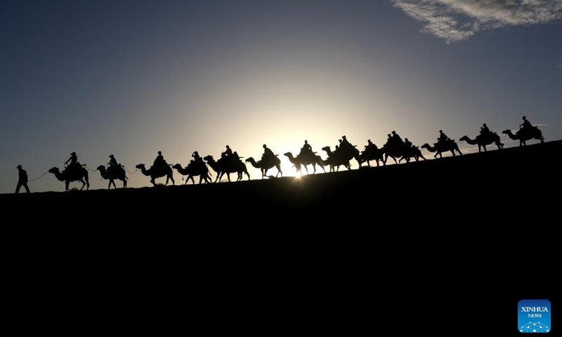 Tourists ride camels at the Mingshashan and the Crescent Lake, an oasis scenic spot in the Gobi Desert in Dunhuang, northwest China's Gansu Province, July 14, 2024. Many tourist destinations across China have recently seen a surge in visitors as the country enters its peak summer tourist season. (Photo by Zhang Xiaoliang/Xinhua)