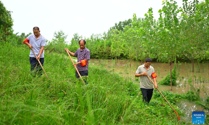 Villagers of Wangjiaba inspect an embankment in Funan County of Fuyang, east China's Anhui Province, July 14, 2024. Measures including monitoring the flood water, inspecting embankment and ensuring flood-control materials have been taken by the authorities of Funan County of Fuyang, east China's Anhui Province, to control the No. 1 Flood for Huaihe River. (Xinhua/Huang Bohan)