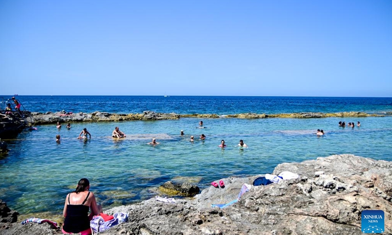 People cool off in the waters of St. Paul's Bay in Qawra, Malta, on July 14, 2024. (Photo by Jonathan Borg/Xinhua)