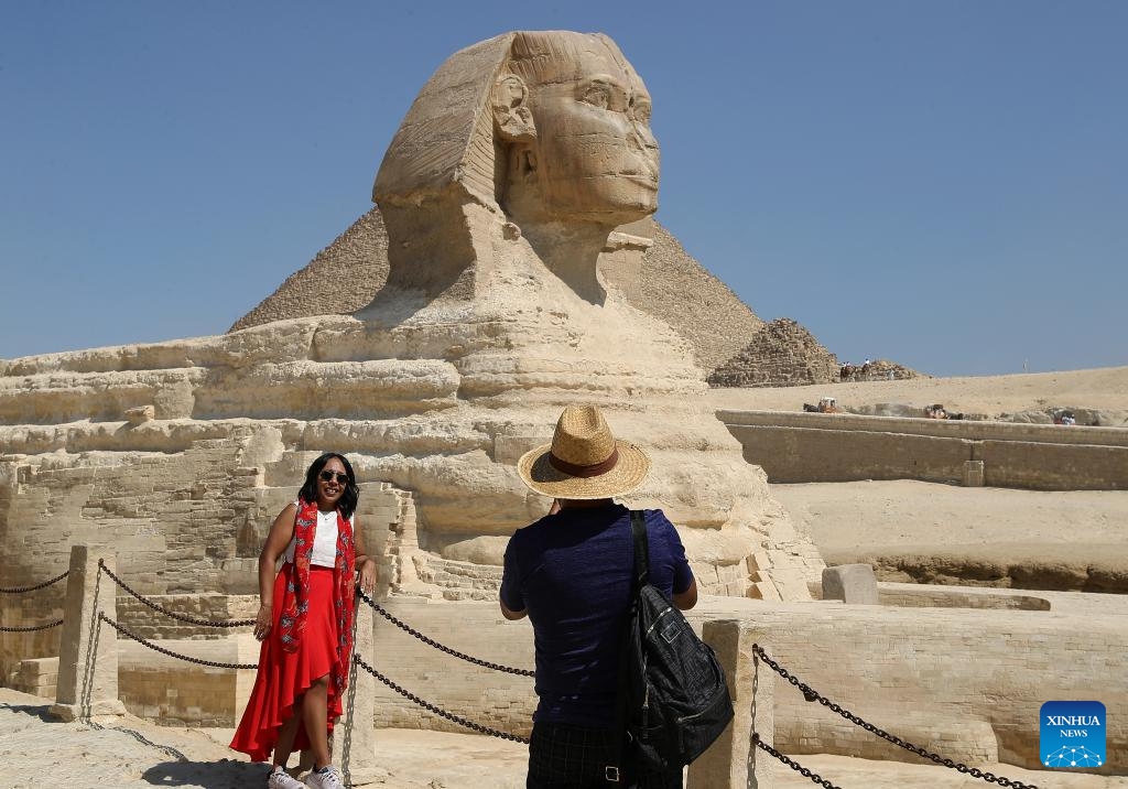 A tourist poses for photo at the Giza Pyramids scenic spot in Giza, Egypt, on July 14, 2024. Tourism revenue of Egypt hit 6.6 billion U.S. dollars in the first half of 2024, surpassing the 6.3 billion dollars during the same period in 2023. (Xinhua/Wang Dongzhen)