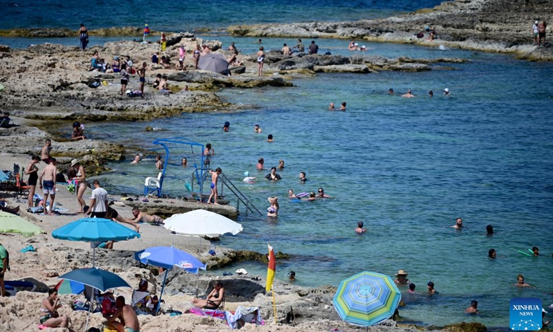 People cool off in the waters of St. Paul's Bay in Qawra, Malta, on July 14, 2024. (Photo by Jonathan Borg/Xinhua)