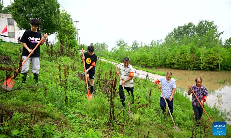 Villagers of Wangjiaba inspect an embankment in Funan County of Fuyang, east China's Anhui Province, July 14, 2024. Measures including monitoring the flood water, inspecting embankment and ensuring flood-control materials have been taken by the authorities of Funan County of Fuyang, east China's Anhui Province, to control the No. 1 Flood for Huaihe River. (Xinhua/Huang Bohan)