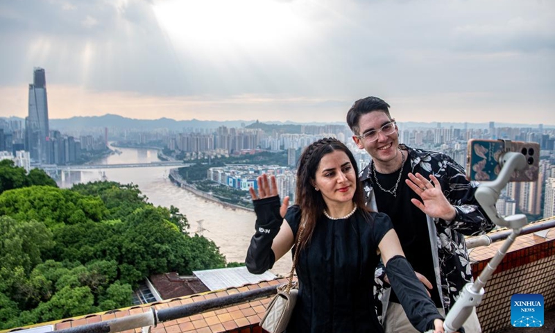 Ilia Anfilatov (R) and Syyra Alee take videos in southwest China's Chongqing Municipality, July 12, 2024. (Xinhua/Tang Yi)