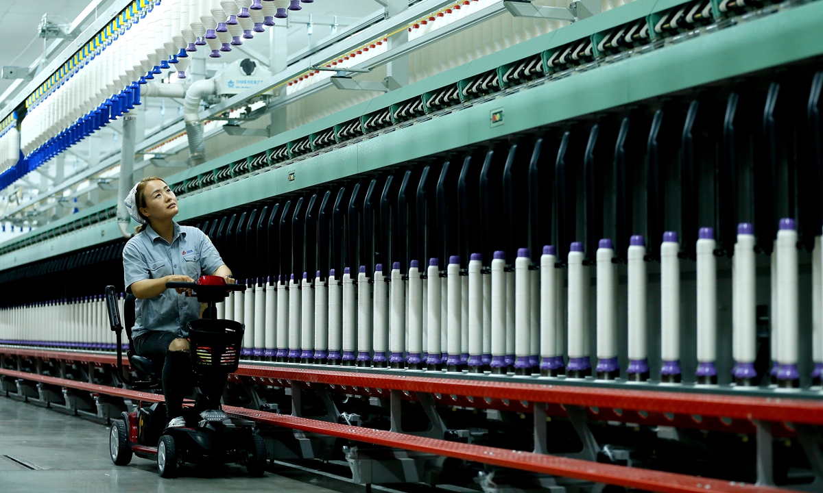 A worker at a textile company in Jimo district, Qingdao, East China's Shandong Province, conducts inspections on a smart spinning production line using an electric bicycle to enhance work efficiency on July 15, 2024. Since the beginning of the year, Jimo has been promoting the transformation of traditional textile firms to become smarter and greener, with the aim of establishing modern smart factories in the region. Photo: VCG