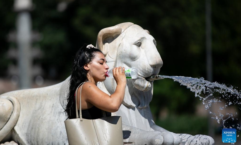 A tourist quenches her thirst with water from Fontana dei Leoni amid a heatwave in Rome, Italy, July 14, 2024. (Xinhua/Li Jing)