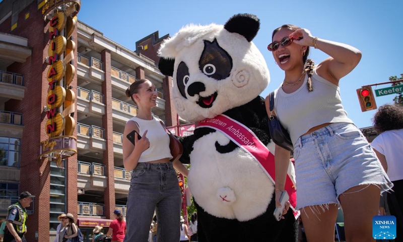 People pose for photos with a giant panda mascot during the 2024 Chinatown Festival in Vancouver, British Columbia, Canada, July 14, 2024. (Photo: Xinhua)