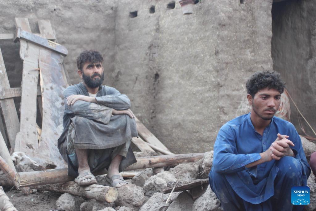 People sit among the rubble after a flash flood in Surkh Rod District, Nangarhar province, Afghanistan, on July 15, 2024. (Photo: Xinhua)