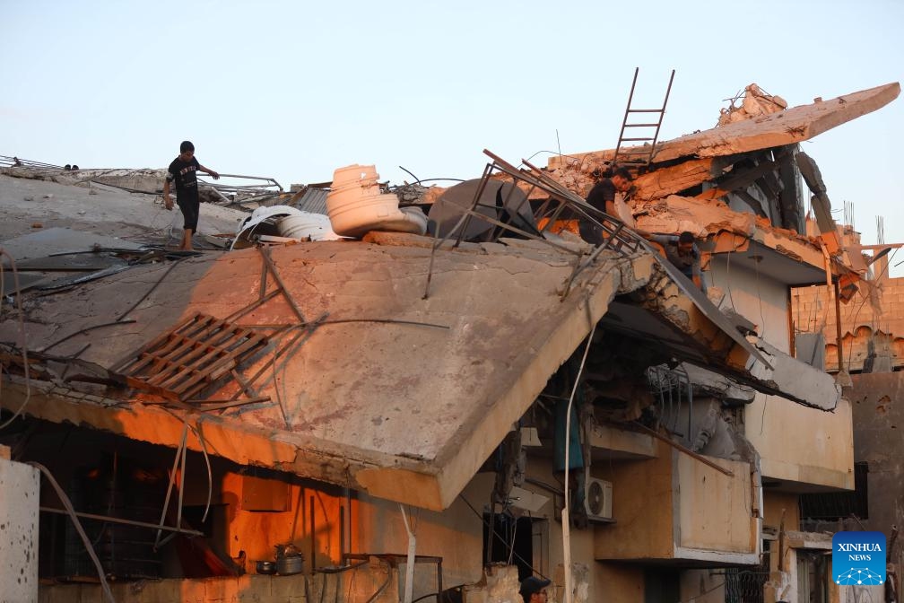 People inspect a building destroyed in an Israeli airstrike in Al-Maghazi refugee camp, central Gaza Strip, on July 15, 2024. (Photo: Xinhua)