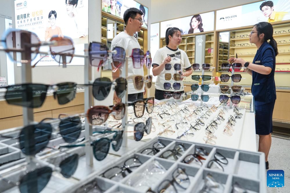 People select glasses at a glasses mall of Danyang City, east China's Jiangsu Province, July 15, 2024. Dubbed as China's spectacles city, Danyang has more than 1,600 companies engaged in the eyewear industry. To maintain its market share and keep up with the new market demand, eyewear companies in Danyang have attached more importance to innovation and branding in recent years and a whole industrial chain has taken shape. (Photo: Xinhua)