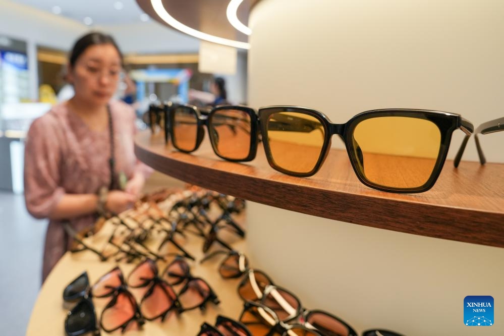 A woman selects glasses at a glasses mall of Danyang City, east China's Jiangsu Province, July 15, 2024. Dubbed as China's spectacles city, Danyang has more than 1,600 companies engaged in the eyewear industry. To maintain its market share and keep up with the new market demand, eyewear companies in Danyang have attached more importance to innovation and branding in recent years and a whole industrial chain has taken shape. (Photo: Xinhua)