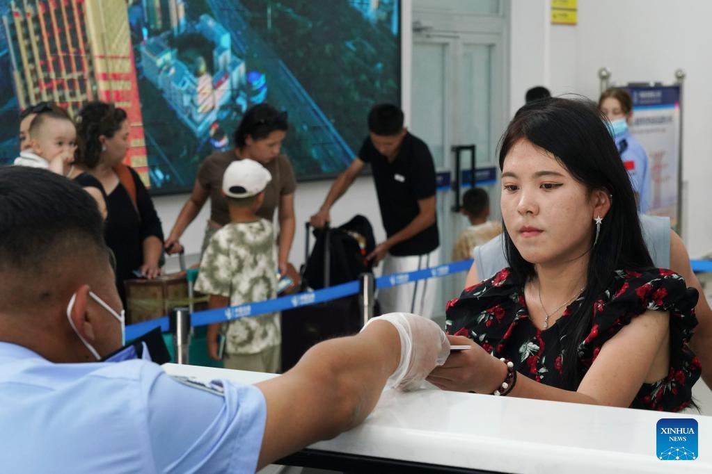 A police officer checks a passenger's travel documents at the Dulata port in Qapqal Xibe Autonomous County, northwest China's Xinjiang Uygur Autonomous Region, July 15, 2024. The Dulata port bordering Kazakhstan has witnessed a boom in cross-border travel since the beginning of July. (Photo: Xinhua)