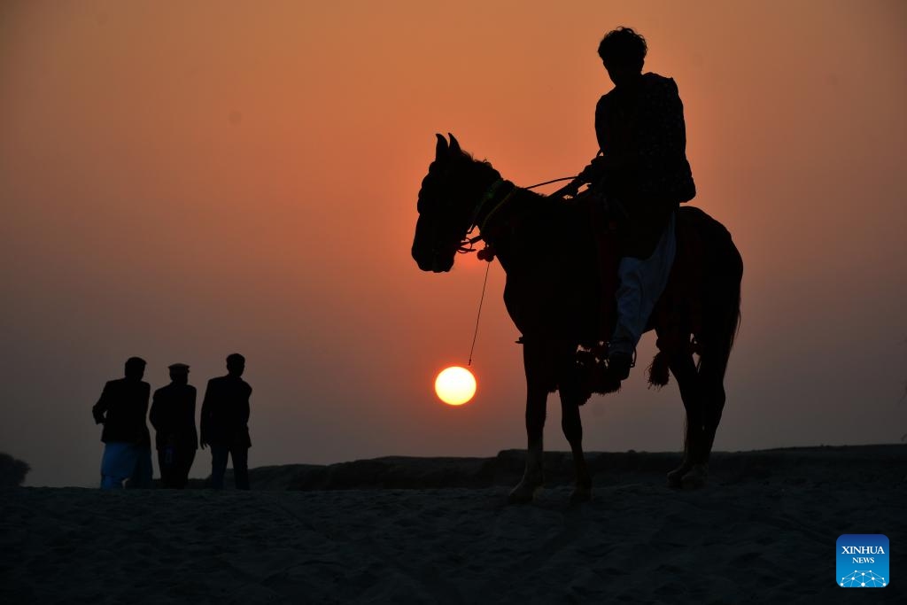 This photo taken on July 17, 2024 shows the silhouette of a woman walking at sunset carrying a water pot on her head in southern Pakistan's Hyderabad. (Photo: Xinhua)