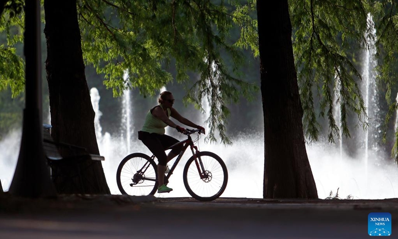 A man rides a bicycle near a fountain at a park in Bucharest, Romania, on July 17, 2024. The Romanian National Meteorological Administration (ANM) has extended its red and orange heat warnings until Wednesday, affecting the entire country amid an ongoing heatwave. (Photo: Xinhua)