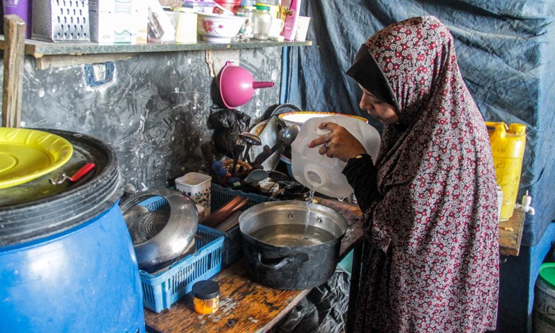 A family member of Ahmed Shinbari pours water into a pot in the northern parts of Gaza, on July 17, 2024. About 67 percent of water, sanitation facilities and infrastructure have been destroyed or damaged in the Gaza Strip, the United Nations Relief and Works Agency for Palestine Refugees in the Near East (UNRWA) said on the social media platform X in June. (Photo: Xinhua)