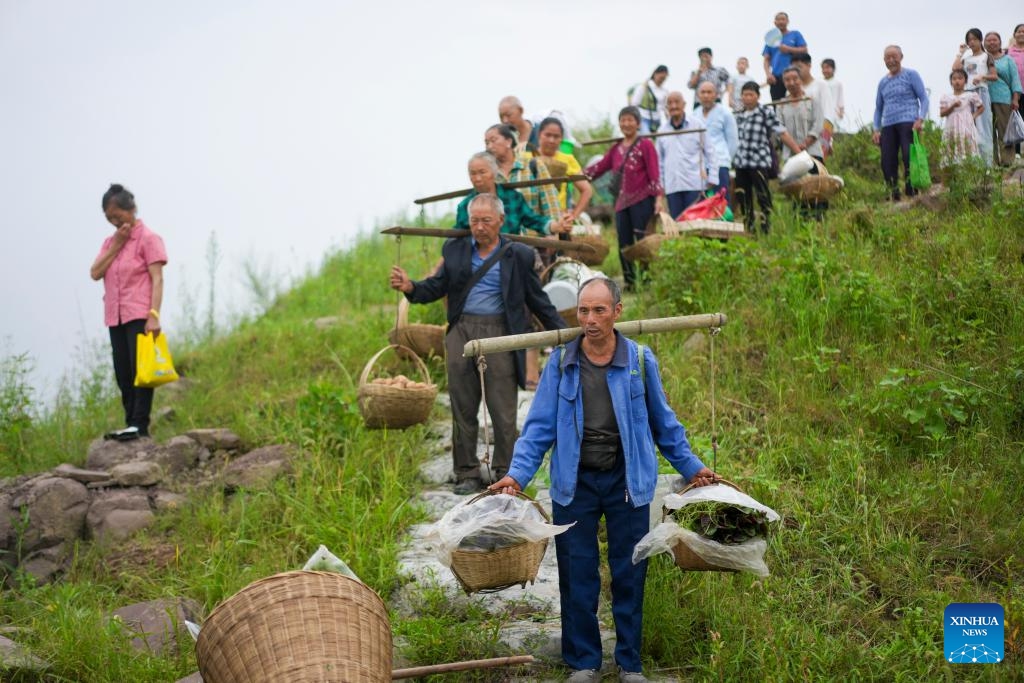 Farmers carrying their produce wait for Yu Zhong Ke 2180 ferry at a stop of the route in southwest China's Chongqing Municipality, July 10, 2024. (Photo: Xinhua)