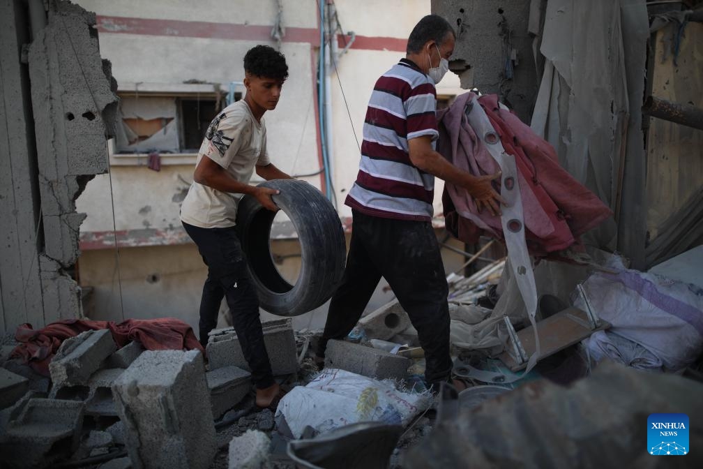 People collect items from the rubble at the Nuseirat refugee camp in central Gaza, on July 18, 2024. During the past 24 hours, the Israeli military killed 54 people and wounded 95 others, bringing the total Palestinian death toll to 38,848 and injuries to 89,459 since the conflict broke out in early October 2023, the Gaza-based health authorities said in a statement on Thursday. (Photo: Xinhua)