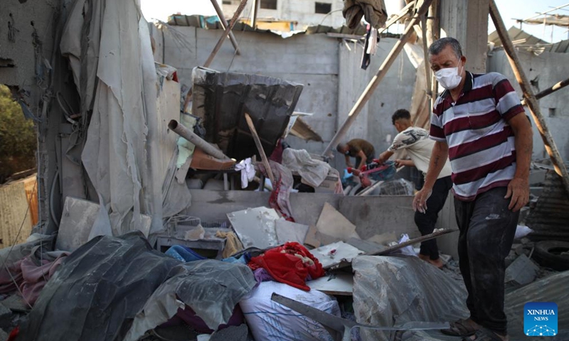 People collect items from the rubble at the Nuseirat refugee camp in central Gaza, on July 18, 2024. During the past 24 hours, the Israeli military killed 54 people and wounded 95 others, bringing the total Palestinian death toll to 38,848 and injuries to 89,459 since the conflict broke out in early October 2023, the Gaza-based health authorities said in a statement on Thursday. (Photo: Xinhua)