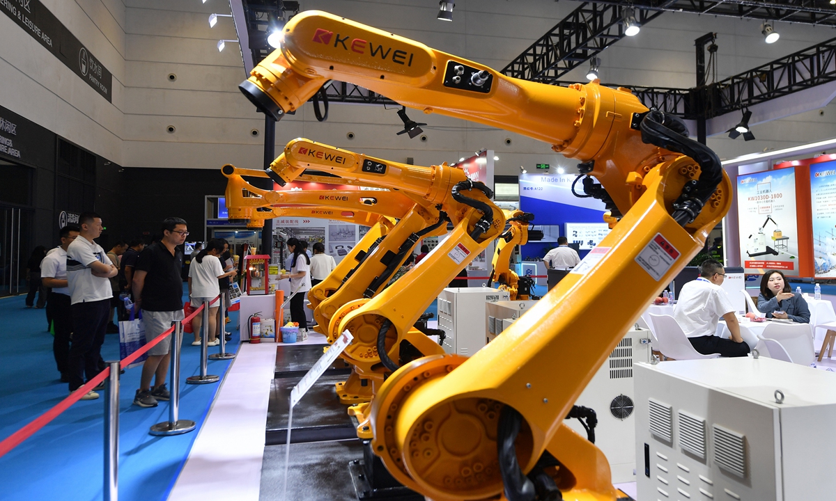 Visitors examine industrial robots at the 26th China Qingdao International Industrial Automation Technology and Equipment Exhibition in Qingdao, East China's Shandong Province on July 18, 2024. China's exports of mechanical and electrical products reached 7.14 trillion yuan ($983.4 billion) in the first half, up 8.2 percent year-on-year, accounting for nearly 60 percent of the country's total export value.  Photo: VCG