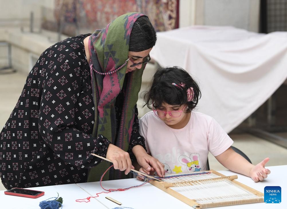 A kid tries carpet making at a carpet museum in Tehran, Iran, July 18, 2024. (Photo: Xinhua)